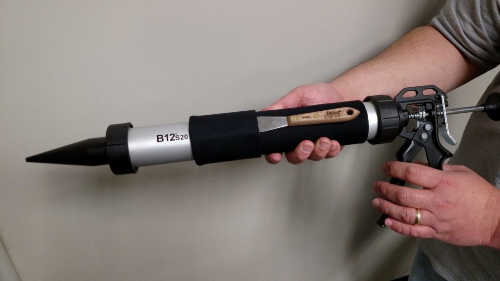 Person holding Albion Caulk Gun with Insulating Barrel Sleve